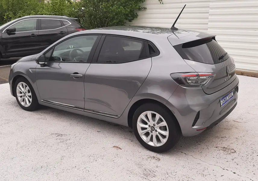 Renault Clio V gris schiste vue 3/4 arrière côté droit, avec jantes alliage et vitres teintées.