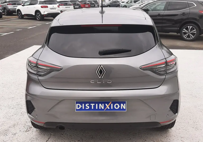 Vue arrière d'une Renault Clio V gris schiste avec feux LED fins et lunette arrière teintée, stationnée en extérieur.