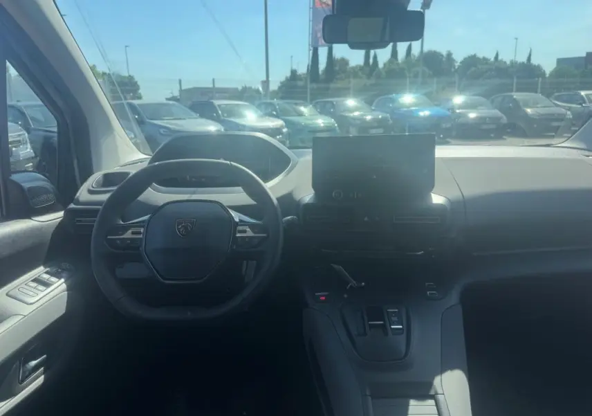 Vue intérieure du tableau de bord du Peugeot Rifter gris 2026, avec volant multifonctions et écran tactile central.