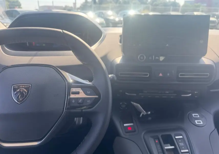 Vue intérieure du Peugeot Rifter 2026 montrant le volant multifonctions en cuir et l'écran tactile central.