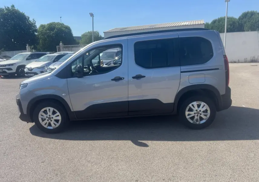 Peugeot Rifter gris vue de profil côté gauche, avec barres de toit et jantes alliage 17 pouces visibles.