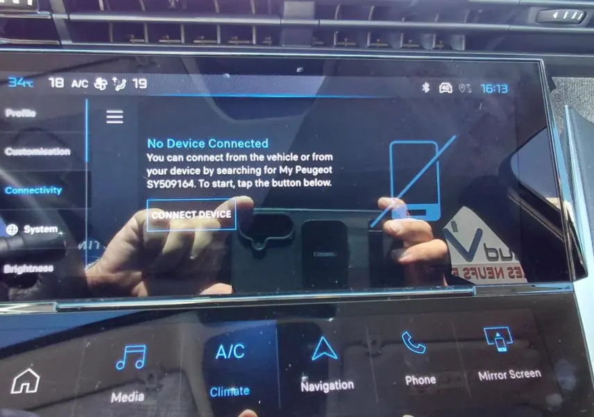 Écran tactile central du tableau de bord du Peugeot 408 Hybrid 2025, affichant le menu de connectivité.