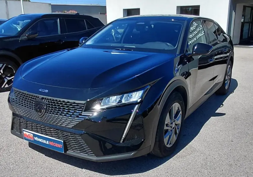 Peugeot 408 Hybrid 145 e-DCS6 Allure noire vue en 3/4 avant, avec calandre distinctive et feux LED verticaux.