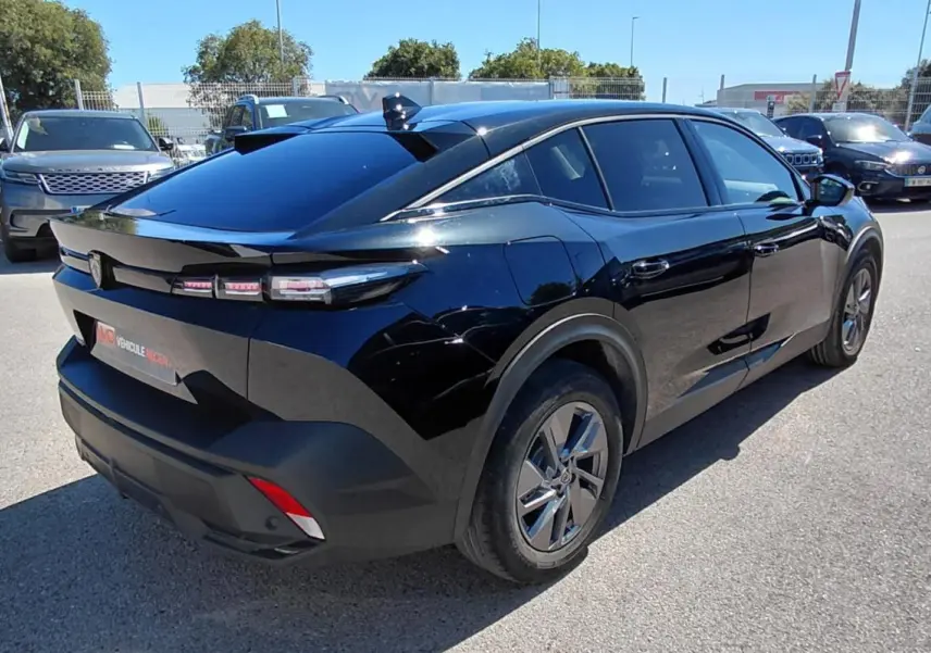 Peugeot 408 Hybrid 145 e-DCS6 Allure noir, vue 3/4 arrière droit, avec feux arrière LED distinctifs et jantes modernes.