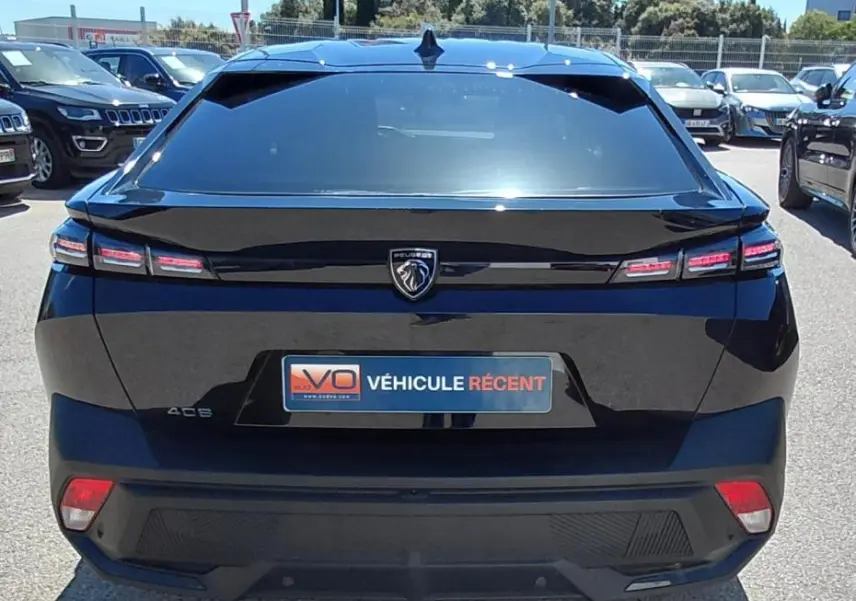 Vue arrière d'une Peugeot 408 noire 2025 avec feux LED distinctifs et logo lion central sur le hayon.