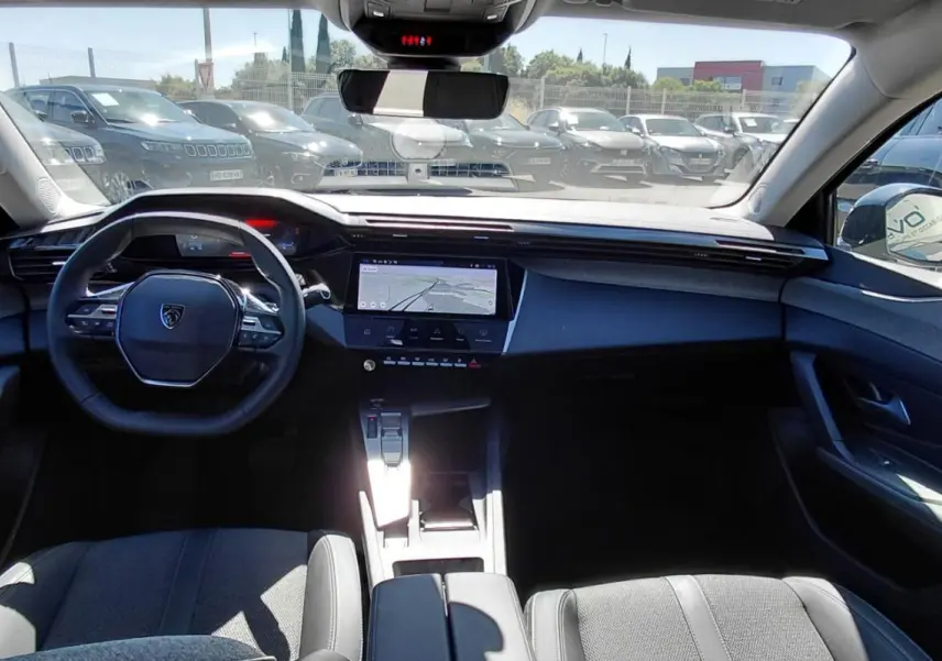 Vue intérieure avant du Peugeot 408 Hybrid 145 e-DCS6 Allure 2025 noir, avec tableau de bord numérique et écran central tactile.