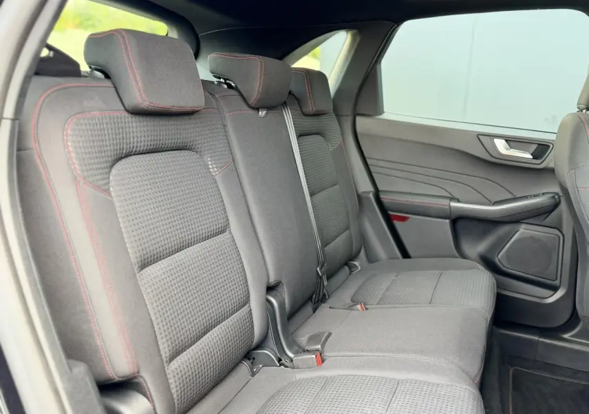 Vue intérieure côté droit des sièges arrière gris foncé avec surpiqûres rouges du Ford Kuga 2023 finition ST-Line.