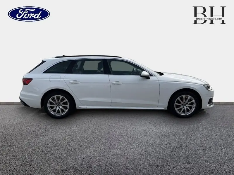Profil droit d'une Audi A4 Avant blanc glacier métallisé, avec jantes alliage et barres de toit noires.