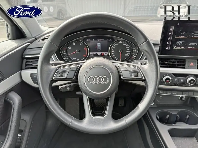 Vue rapprochée du volant cuir multifonction Audi A4 Avant 30 TDI avec tableau de bord et écran central visibles.