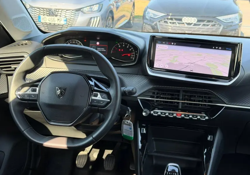 Intérieur de la Peugeot 208 noir Perla Nera, vue du poste de conduite avec tableau de bord et écran tactile central.