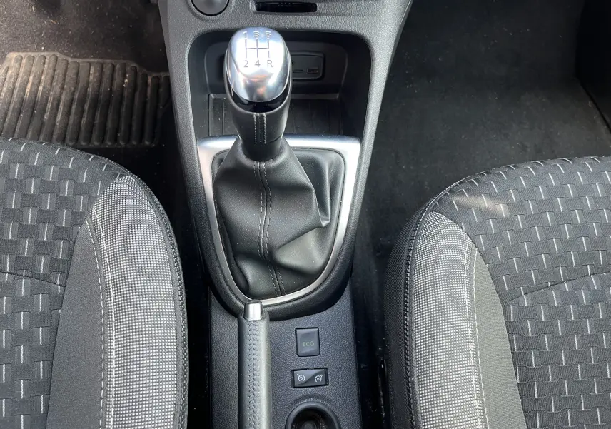 Le levier de vitesses manuel et le frein à main entre deux sièges tissu gris foncé à motifs dans un Renault Captur 2019.