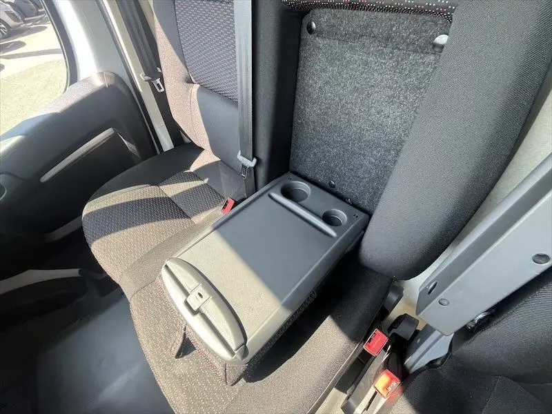 Vue intérieure côté droit du Peugeot Boxer FGN 2021, siège passager avec accoudoir central relevé et porte-gobelets intégrés.