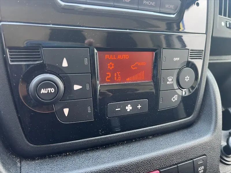 Panneau de commande de climatisation automatique du Peugeot Boxer FGN 2021, affichage rouge et boutons noirs.