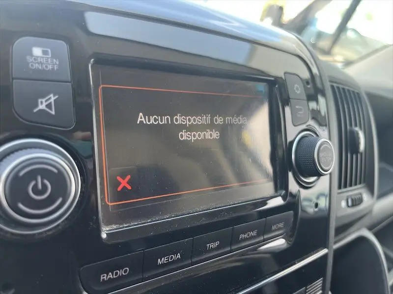 Gros plan sur l'écran multimédia du tableau de bord du Peugeot Boxer blanc, affichant "Aucun dispositif de média disponible".