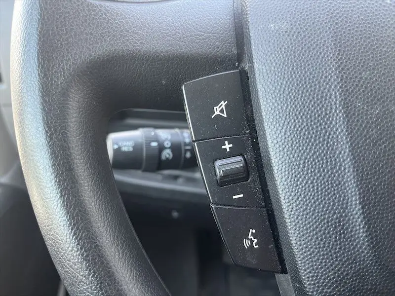 Gros plan sur les commandes de volume et de son du volant noir du Peugeot Boxer FGN blanc, version 2021.