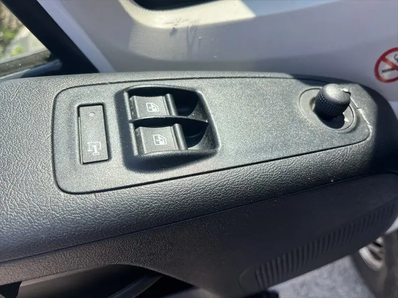 Gros plan sur les commandes de lève-vitres électriques et rétroviseur côté conducteur du Peugeot Boxer blanc 2021.