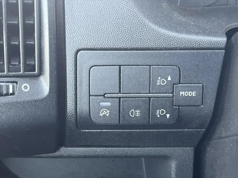 Gros plan sur les commandes d'éclairage et mode du tableau de bord du Peugeot Boxer FGN blanc, intérieur noir.