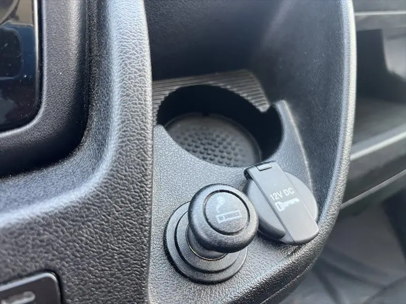 Gros plan sur l'allume-cigare et prise 12V dans l'habitacle du Peugeot Boxer FGN blanc de 2021.