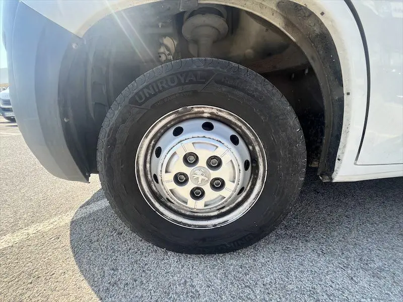 Gros plan sur la roue avant gauche du Peugeot Boxer blanc, avec jante acier et logo Peugeot au centre.