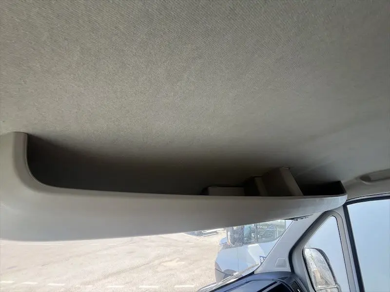Rangement intérieur au-dessus du pare-brise côté passager dans un Peugeot Boxer blanc 2021 vue depuis l'habitacle.