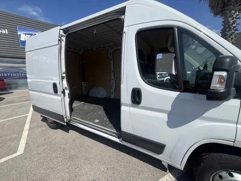 Vue latérale droite d'un Peugeot Boxer blanc 2021 avec porte coulissante ouverte montrant l'espace de chargement vide.