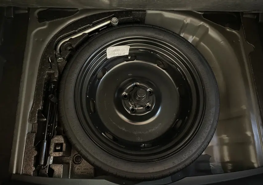 Gros plan sur la roue de secours compacte noire du coffre du CUPRA Formentor 2025 en peinture Noir Minuit.