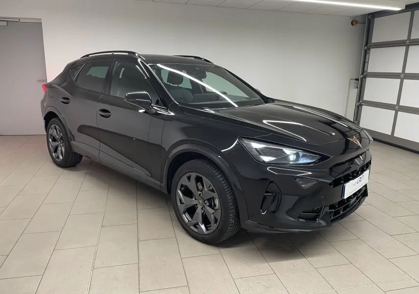 SUV CUPRA Formentor noir minuit vu en 3/4 avant droit dans un garage, avec phares allumés et jantes foncées.