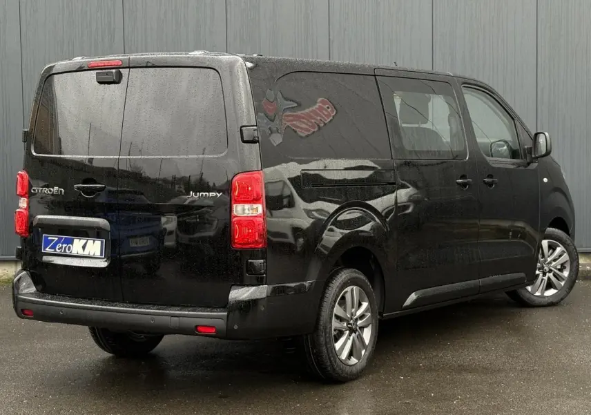 Vue 3/4 arrière droit d’un Citroën Jumpy XL noir Perla avec jantes alliage 17'' grises sous la pluie.
