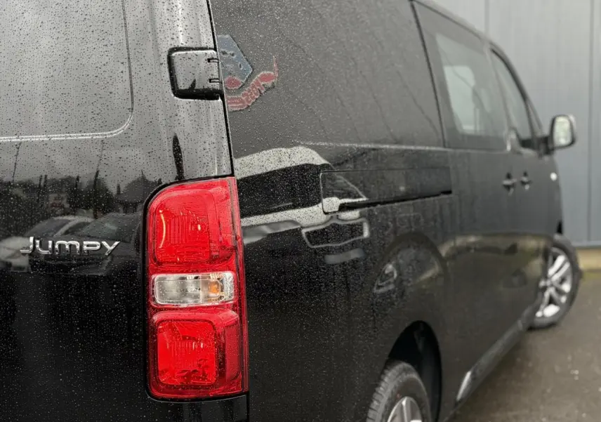 Vue 3/4 arrière droite d’un Citroën Jumpy XL noir Perla avec feux arrière rouges et jantes alliage 17 pouces.
