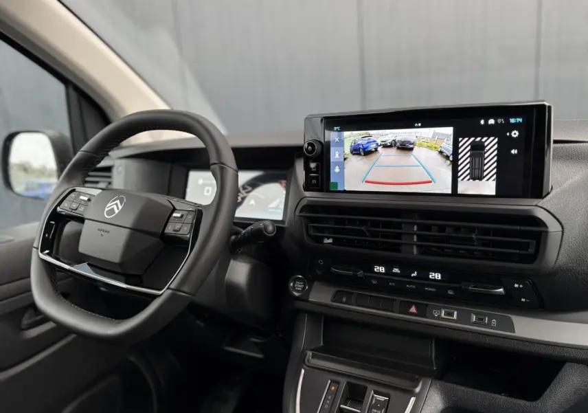 Intérieur du Citroën Jumpy XL 2025 vu côté conducteur, volant cuir et écran tactile affichant caméra de recul.