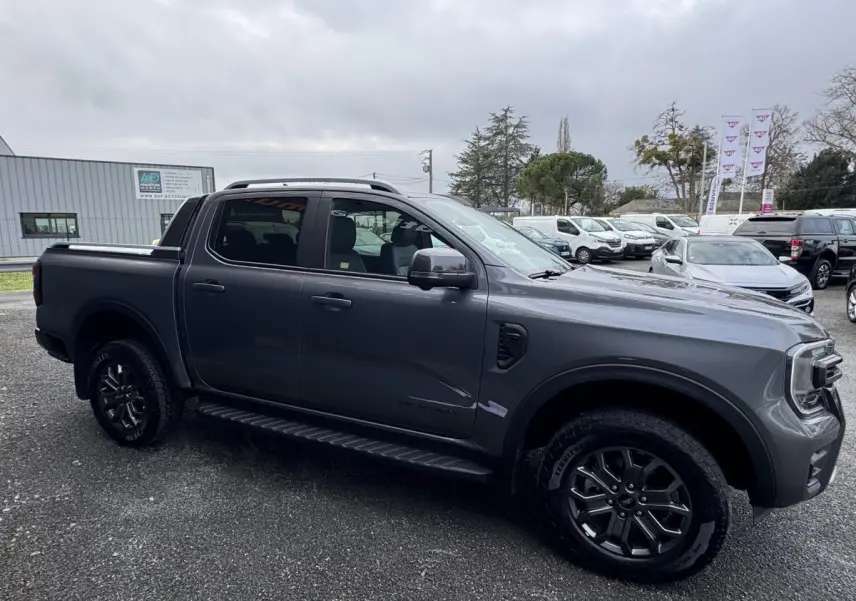 Ford Ranger 2025 gris foncé vu de profil côté gauche, avec jantes noires et double cabine WILDTRAK.