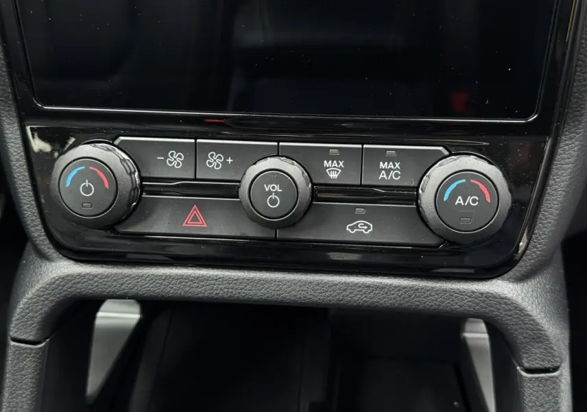 Gros plan sur la console centrale noire du Ford Ranger 2025, avec commandes climatisation et volume visibles.