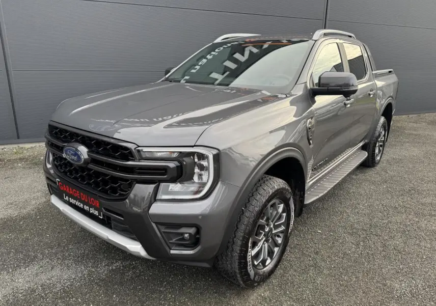 Ford Ranger 2025 gris vue 3/4 avant droit, avec calandre noire et marchepieds latéraux en aluminium.