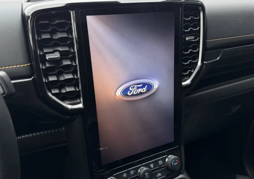 Vue rapprochée du tableau de bord noir du Ford Ranger 2025 avec grand écran tactile vertical affichant le logo Ford.
