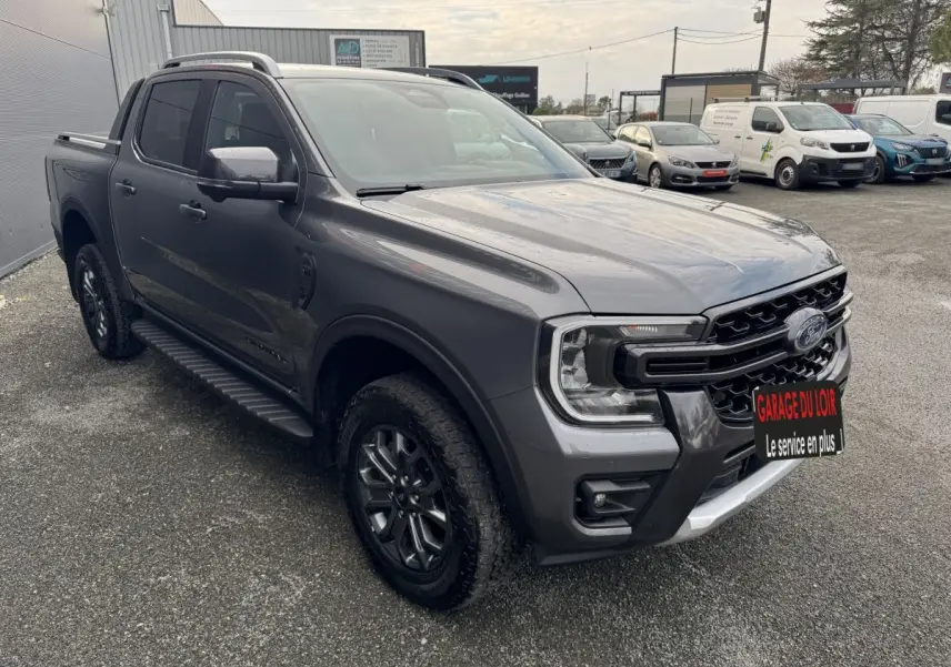 Ford Ranger gris foncé vu en 3/4 avant droit, avec calandre noire et jantes alliage noires.
