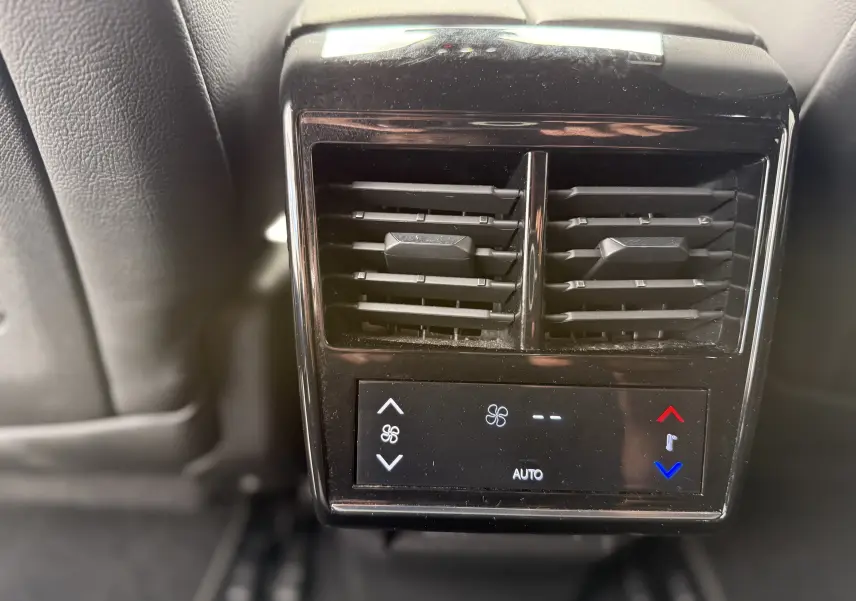 Gros plan sur la commande de climatisation arrière noire du DS7 BlueHDi 130 Pallas, intérieur cuir noir.