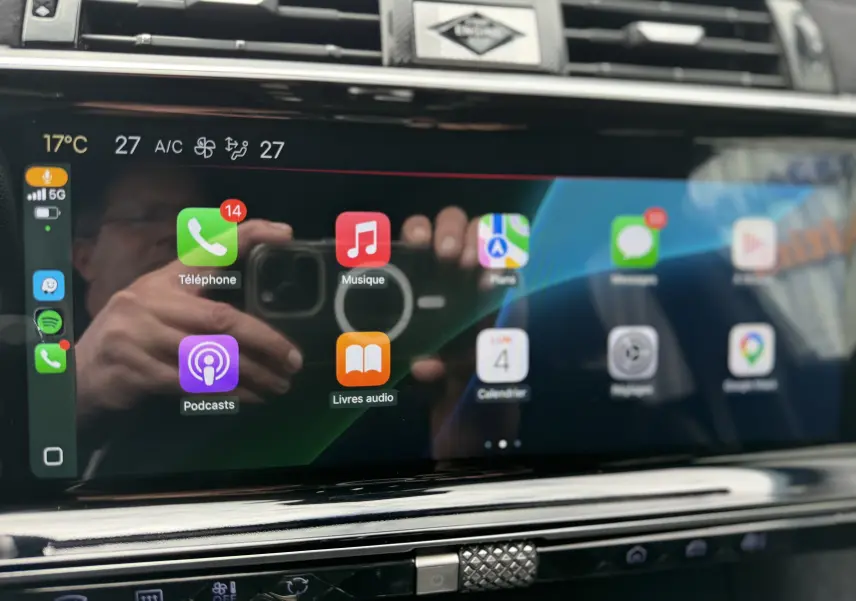Écran tactile central du DS7 2025 affichant les applications Apple CarPlay avec commandes climatisation visibles en dessous.