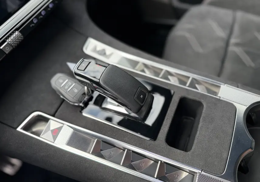 Gros plan sur la console centrale du DS7 BlueHDi 130 Pallas, avec levier de vitesse automatique et finitions en alcantara gris.