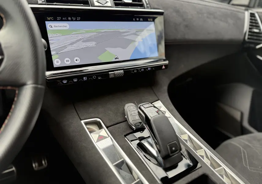 Vue intérieure du DS7 BlueHDi 130 2025 montrant la console centrale avec levier de vitesse automatique et écran tactile de navigation.