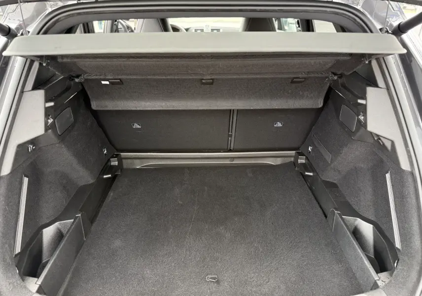 Coffre ouvert vu de l'arrière du DS7 gris titane, montrant un espace de chargement propre et bien agencé.