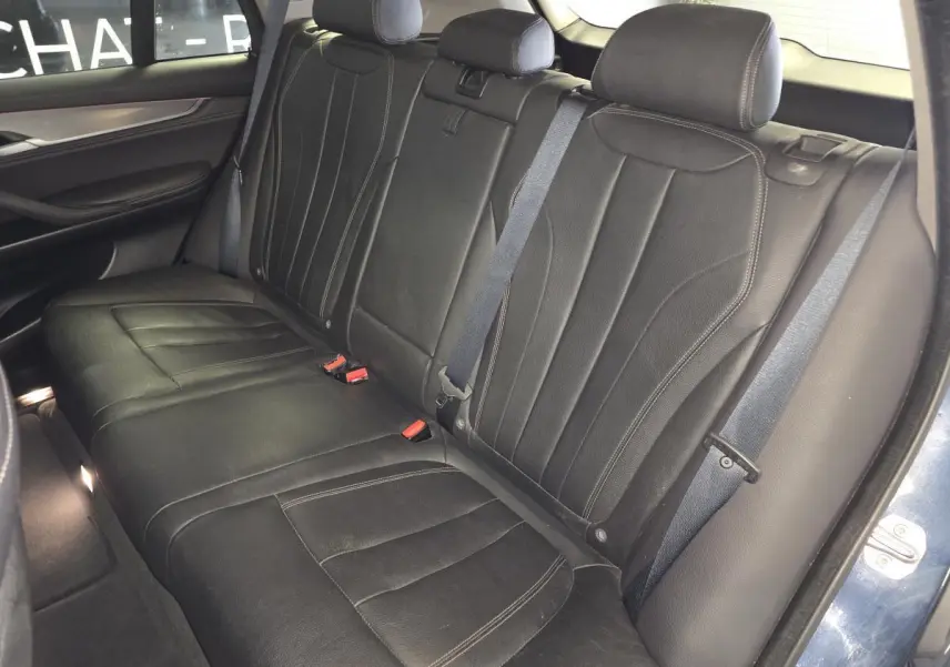 Vue intérieure des sièges arrière en cuir noir du BMW X5 sDrive 25d 2018, avec ceintures de sécurité visibles.