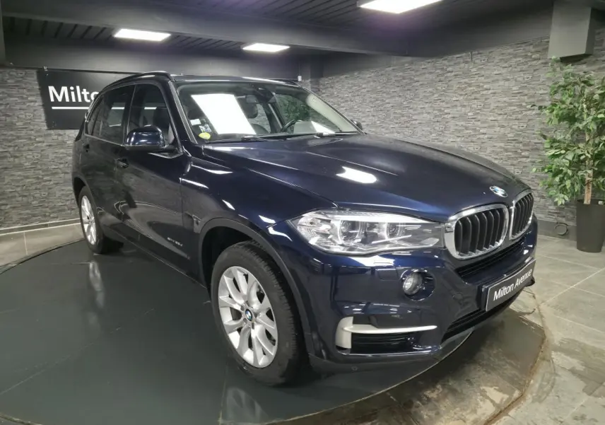 BMW X5 sDrive 25d bleu métallisé vue 3/4 avant droit avec jantes alliage 19'' et calandre chromée.