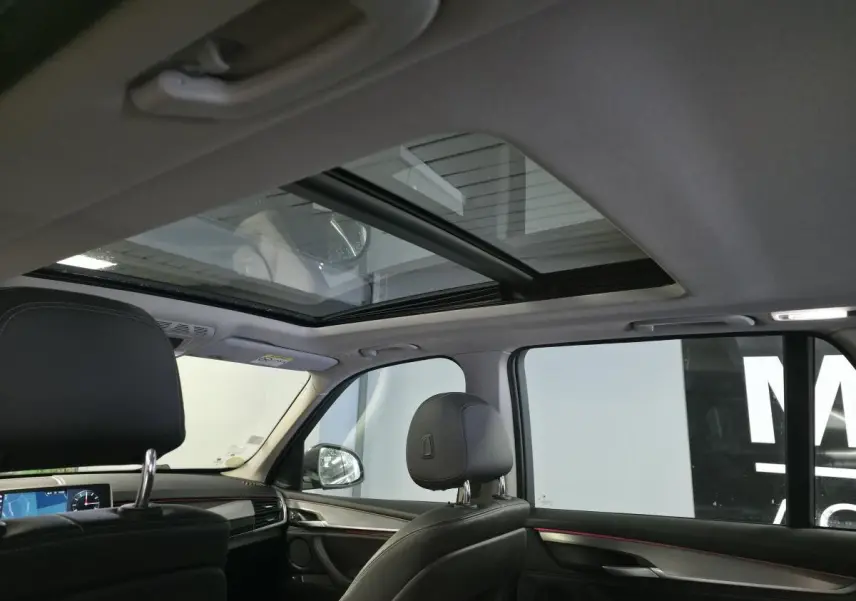 Vue intérieure du toit ouvrant panoramique en verre et des sièges avant en cuir noir du BMW X5 sDrive 25d 2018.