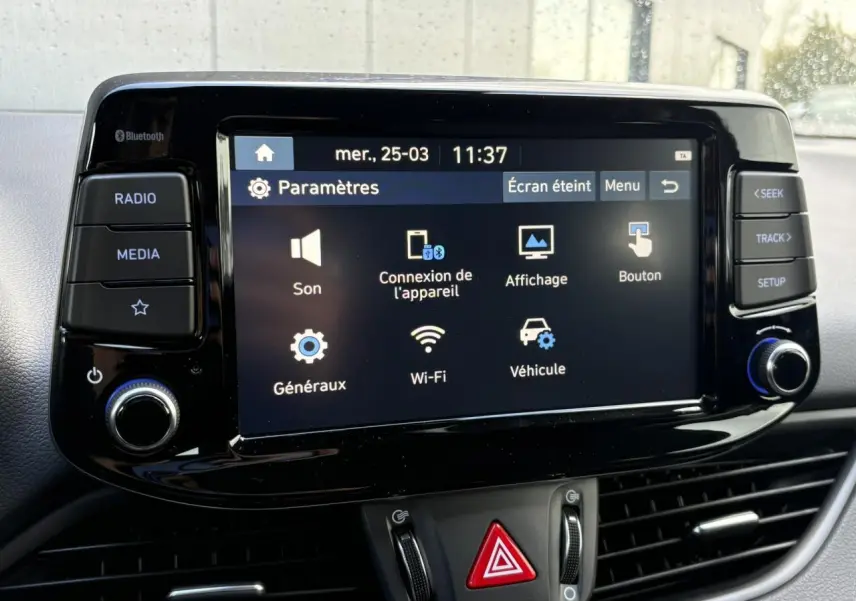 Écran tactile central du système multimédia de la Hyundai i30 SW T-GDI 120 Modern, vue de face, intérieur noir.