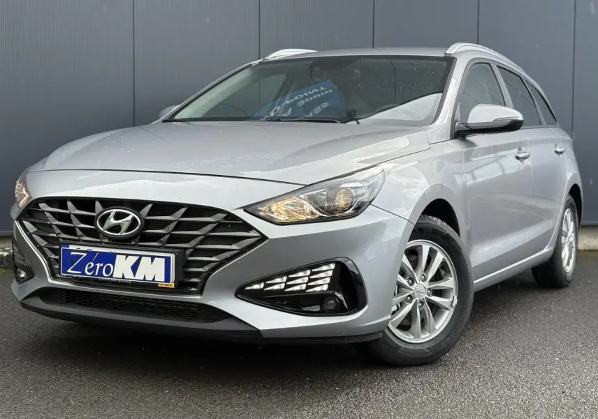 Hyundai i30 SW T-GDI 120 Modern gris argent, vue 3/4 avant droit avec calandre noire et jantes alliage.