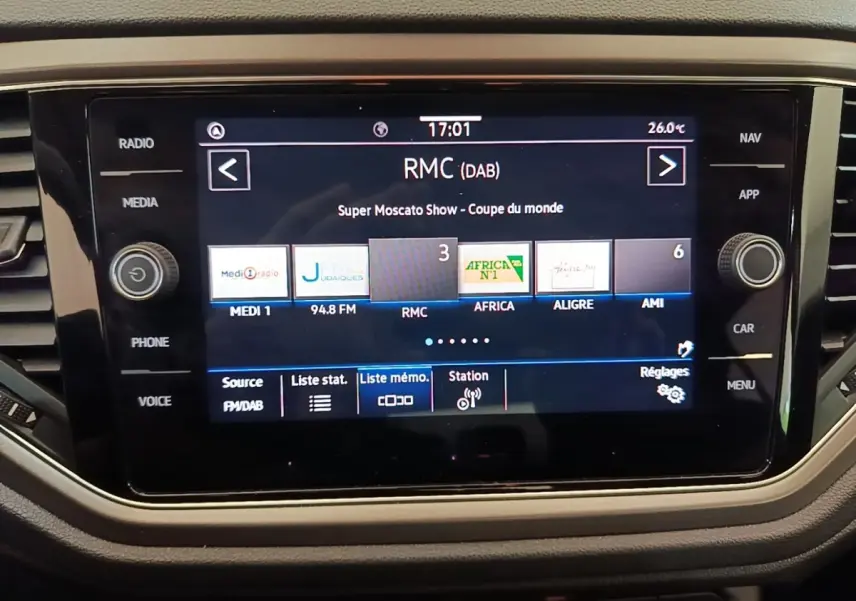 Écran tactile central du Volkswagen T-Roc 1.5 TSI bleu, affichant les stations radio avec interface moderne.