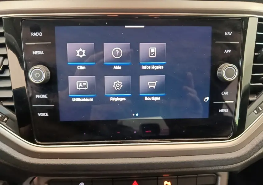 Écran tactile central du tableau de bord du Volkswagen T-Roc 1.5 TSI bleu, affichant le menu des réglages.
