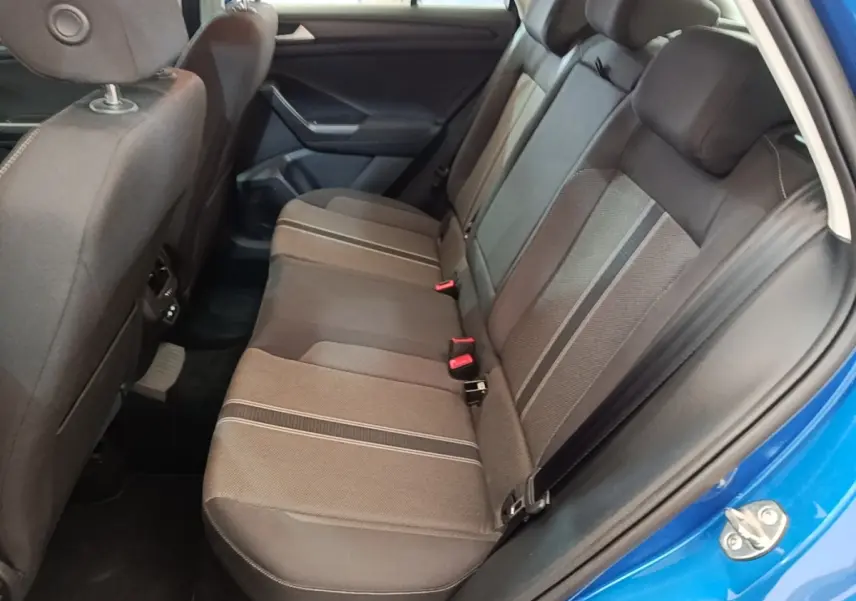 Vue intérieure côté arrière droit du Volkswagen T-Roc bleu 2020, montrant la banquette arrière en tissu gris à motifs rayés.