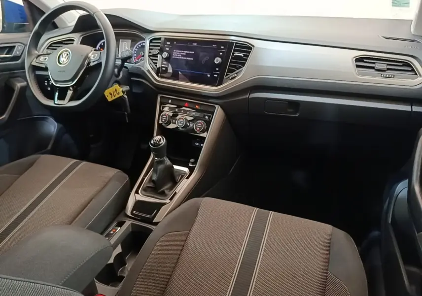 Vue intérieure avant du Volkswagen T-Roc 1.5 TSI 2020, montrant le volant cuir, tableau de bord et levier de vitesse manuel.