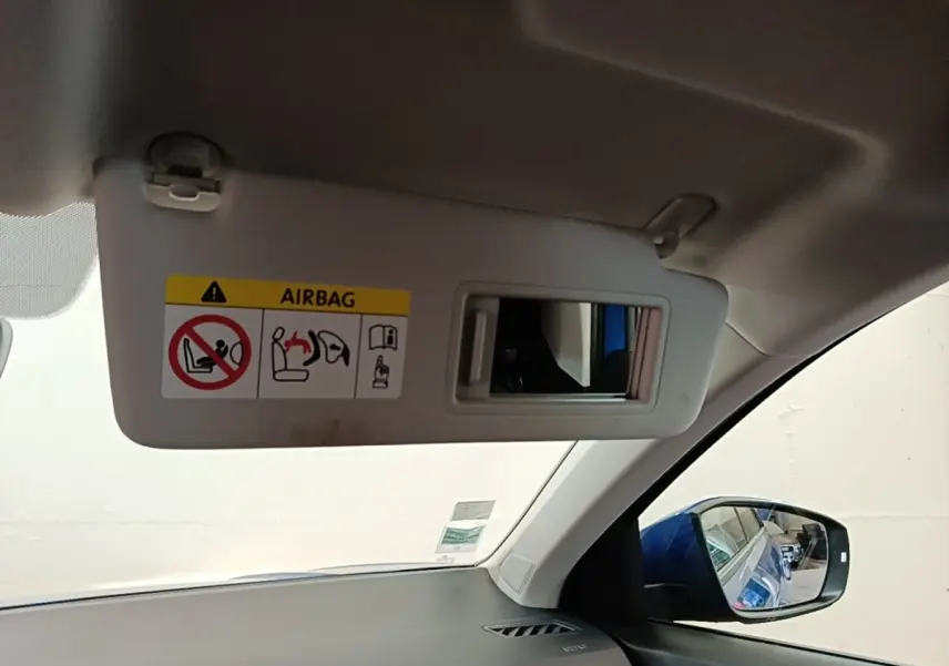 Intérieur du Volkswagen T-Roc bleu 2020, vue sur pare-soleil avec miroir et rétroviseur latéral droit.